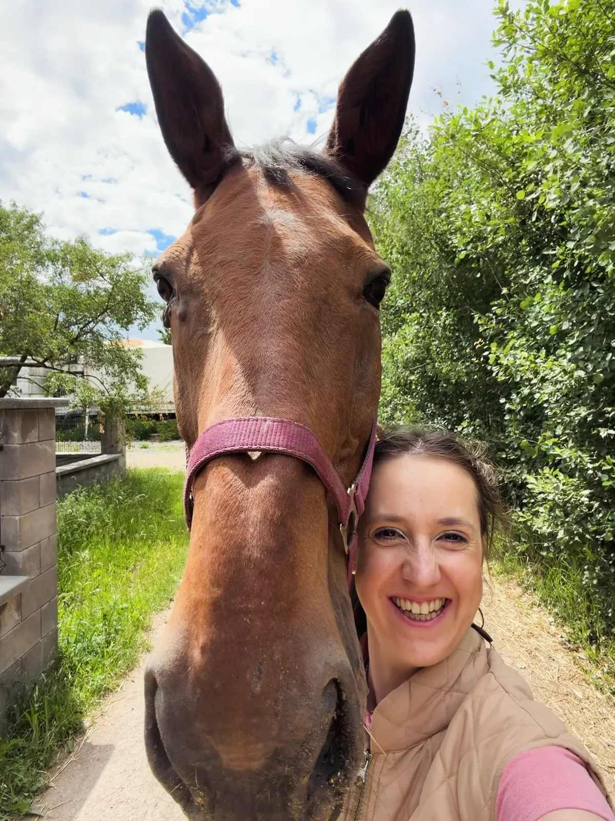 Johana close to a horse’s head, smiling warmly